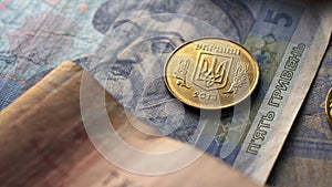 Warsaw, Poland 01.01.2021 - Close up one coin over Ukrainian hryvnia. Currency accounting and finances concept