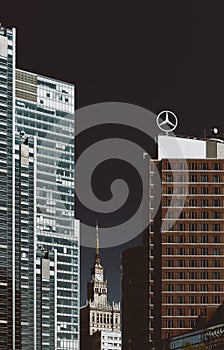 Warsaw, Poland - August 8th, 2021: Skyscaper with Mercedes-Benz logo near Palace of Science and Culture iconic building in Warsaw