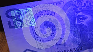 Warsaw, Poland 01.01.2021 Polish zloty under the UV lamp. Testing paper money for counterfeiting concept. extreme close