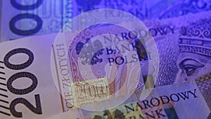 Warsaw, Poland 01.01.2021 Polish zloty under the UV lamp. Testing paper money for counterfeiting concept. extreme close