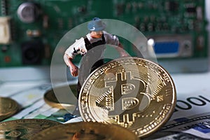 WARSAW / POLAND - September 23 2018: bitcoins new virtual currency. A worker is digging on golden bitcoin with dollar background