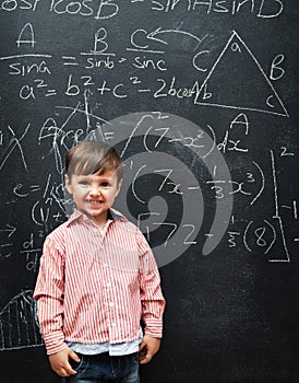 It was as easy as 1,2,3. a young boy with a blackboard full of math equations.