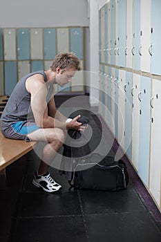 That was a good session. Crppped shot of a young man in the gym after a solid workout.