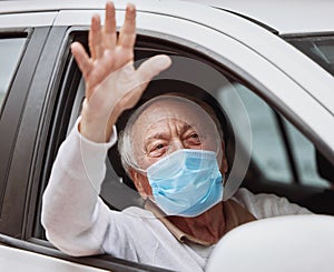 That was a quick process. Shot of a senior man waving while sitting in his car at a drive through vaccination site.