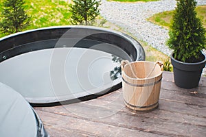 Wash basin wooden bucket for bath. Sauna equipment. Jacuzzi on the terrace, sunny patio