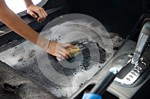 Wash the car carpet.Detailing on interior of modern car.Clean by using a brush and cleaning solution on the car carpet