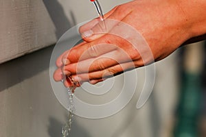 Wash hands, a man washes his hands under the tap with soap and water