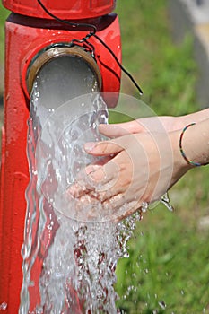 Wash hands under the jet of water from a fire hydrant