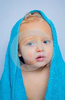 Wash infant hygiene and health and skin care. Little baby smiling under a white towel. Image of cute baby boy covered