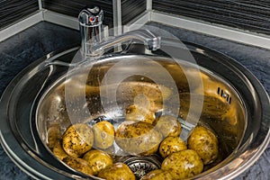 Wash the raw potatoes in the sink. Symbolizes rural home cooking.