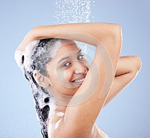 A wash was all I needed. a young woman washing her hair in the shower against a blue background.