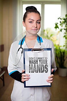 Wash your hands lettering. Young female doctor holding a sign. Virus spread prevention messures. Covid-19 coronavirus