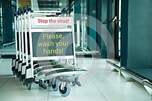 Wash your hands sign on airport trolley