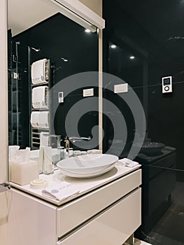 Washbasin-bowl with a chrome-plated faucet on a large cabinet in front of a mirror in the bathroom