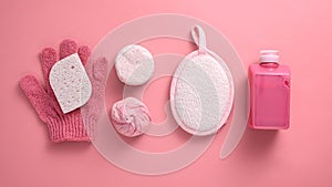 Washcloth, sponge, gel, soap, salt on pink background, bath and Spa day concept, top view, flat lay