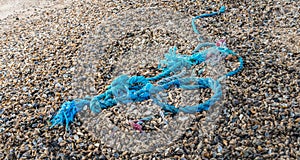 Washed ashore frayed blue braided synthetic rope from close