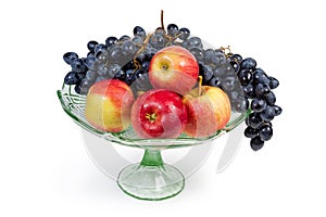Washed blue grapes and apples in vintage glass fruits vase