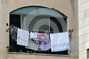 The washed clothes are dried on a clothesline outside the apartment window