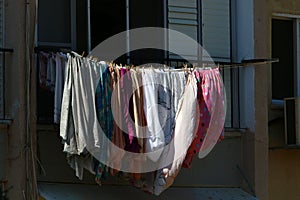 The washed clothes are dried on a clothesline outside the apartment window