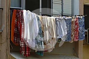 The washed clothes are dried on a clothesline outside the apartment window