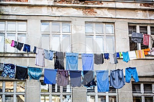 Washed clothes drying outside of an old house. Washed clothes drying. Fresh clean clothes are drying outside. Clothes