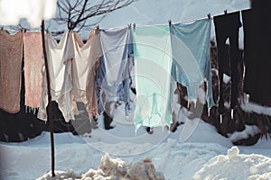 Washed clothes hang on a string in the cold, hardened