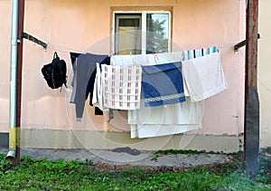 Washed linen is dried on ropes against the background of a residential building