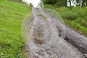 Washed out dirt road on hillside with scour after rain