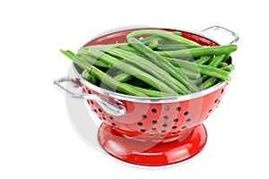 Washed string beans in red colander.