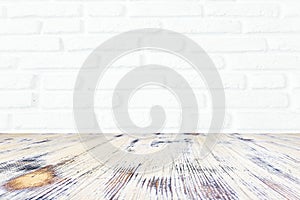 Washed wood table with white brick wall texture background