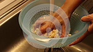Washing canned beans close up in kitchen sink