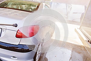 Washing car with high pressure washer at self-service car photo