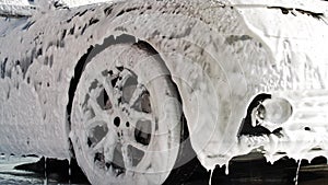 Washing car on a touchless car wash with foam and a high pressure water