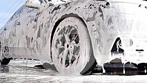 Washing car on a touchless car wash with foam and a high pressure water