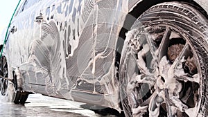 Washing car on a touchless car wash with foam and a high pressure water