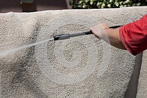 Washing carpets with high pressure washer. Cleaning the carpet with a gun for washing high pressure water