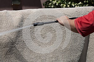 Washing carpets with high pressure washer. Cleaning the carpet with a gun for washing high pressure water