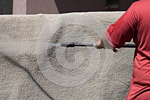 Washing carpets with high pressure washer. Cleaning the carpet with a gun for washing high pressure water