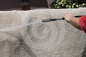 Washing carpets with high pressure washer. Cleaning the carpet with a gun for washing high pressure water