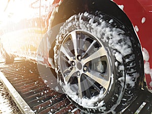 washing cars alloy wheels on a car red car with active foam