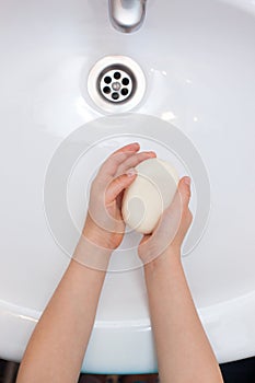 Washing child`s hands with antibacterial soap over the white sink. Protection against bacteria, coronavirus