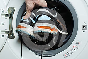 Washing dirty sneakers in the washing machine. Cleaning trail running shoes