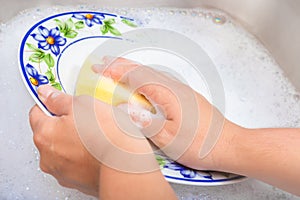 Washing the dishes on soapy water photo