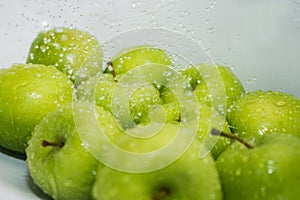 Washing fruit. Wet apples in the shower.