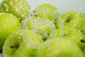 Washing fruit. Wet apples in the shower and water drops.