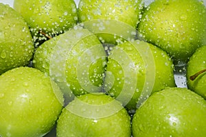 Washing fruit. Wet apples in the shower and water drops.