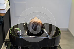 Washing hair on a blurred backdrop of a beauty salon. Background, selective focus