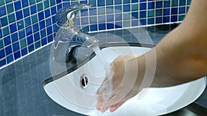 Washing hands and closing tap closeup