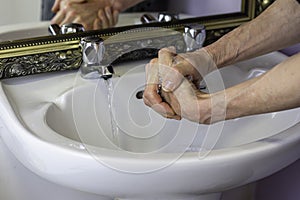 Washing hands in domestic bathroom to prevent spread of coronavirus