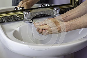 Washing hands in domestic bathroom to prevent spread of coronavirus